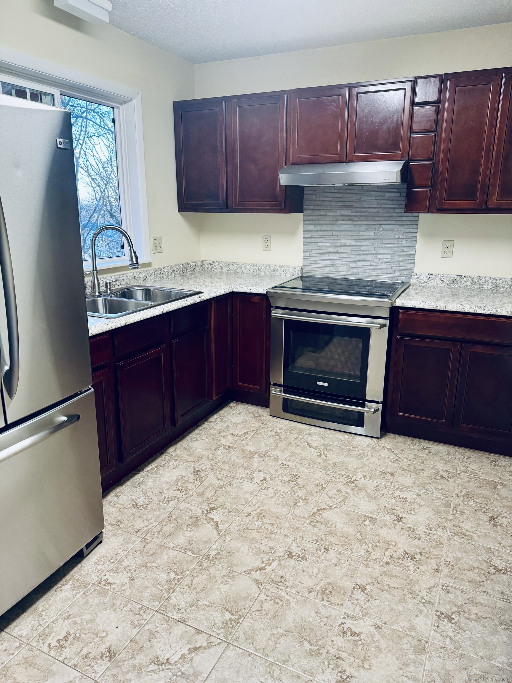 a kitchen with granite countertop a stove and a refrigerator