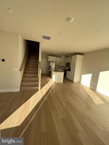 a view of a bedroom with wooden floor and furniture