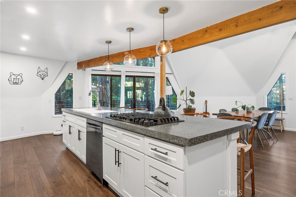 1349 Valley View Way Crestline, CA 92325 - Photo 14 of 43 a kitchen with a stove a sink a dining table and chairs with wooden floor