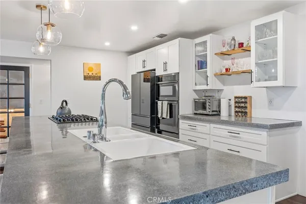 a kitchen with stainless steel appliances granite countertop a sink and a refrigerator