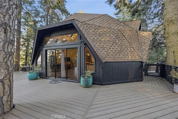 a view of a house with large windows and plants