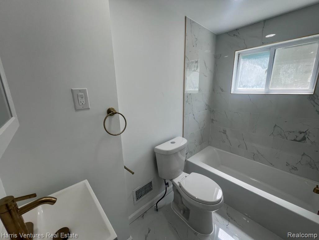 22144 Moross Road Grosse Pointe, MI 48236 - Photo 15 of 16 Bathroom featuring white wall paint, a white bathtub, and a window above the tub