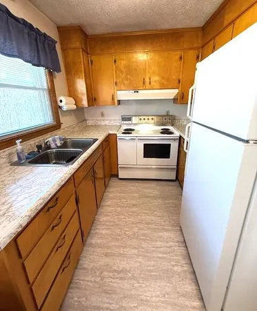 a kitchen with a sink a stove and a refrigerator