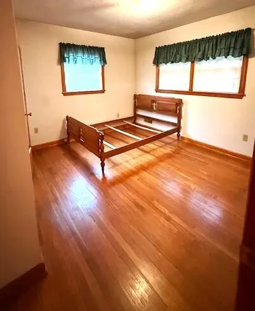 a living room with hardwood floor and a window