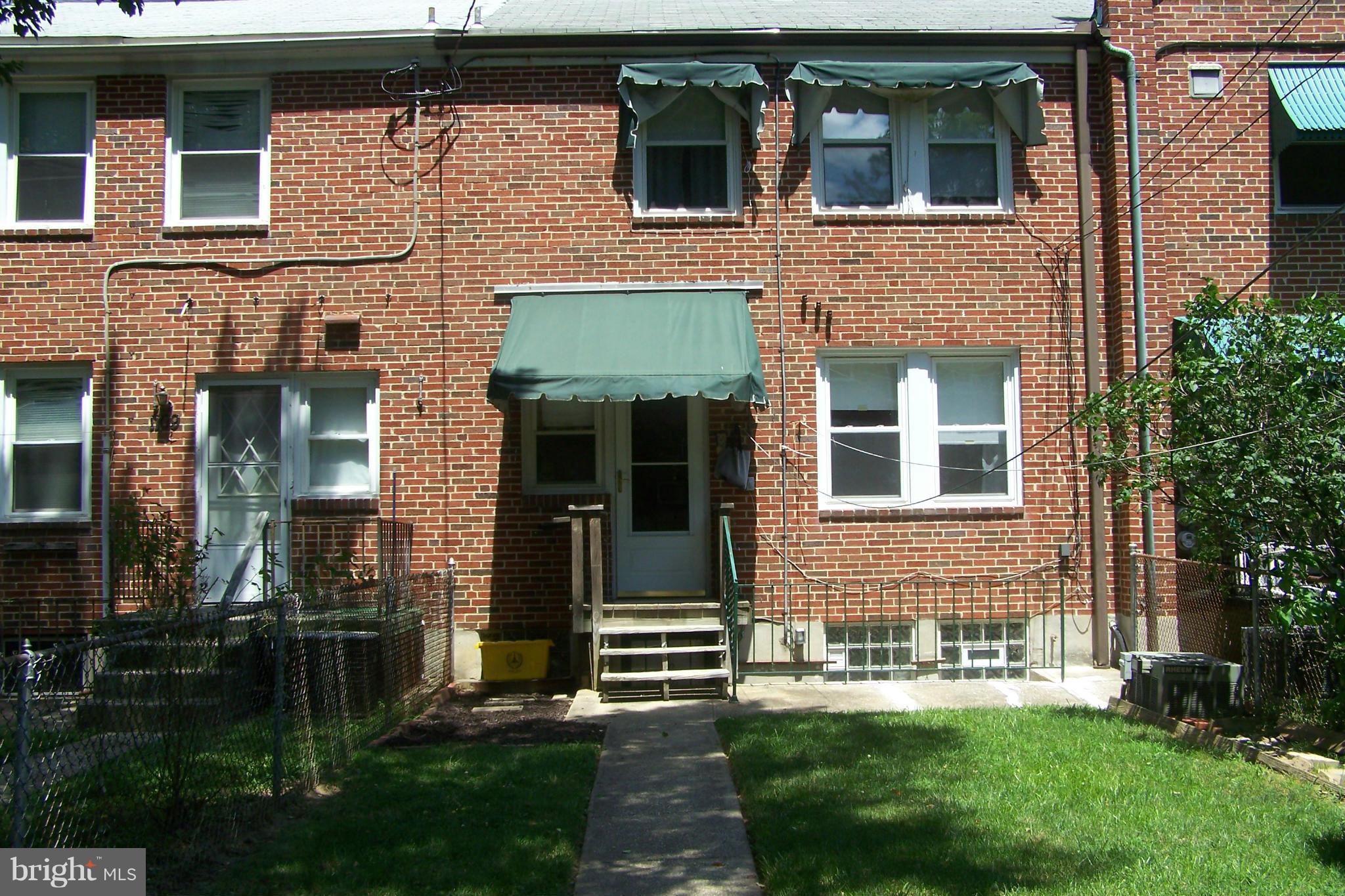 1111 Granville Road Baltimore, MD 21207 - Photo 18 of 19 a view of a brick house with a yard large tree and a large window