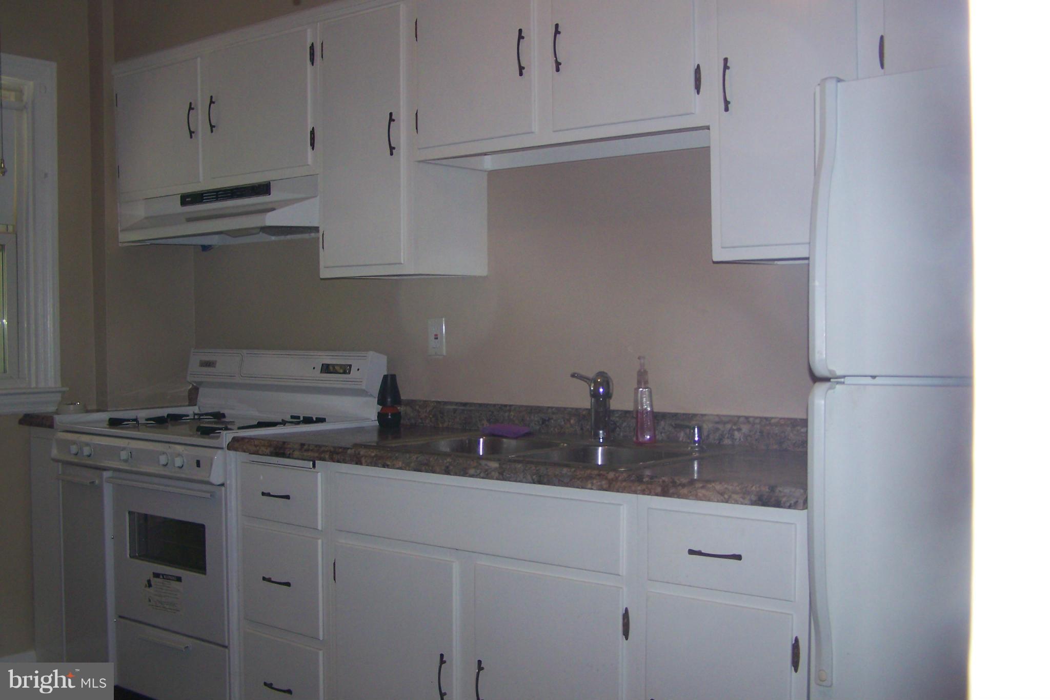 1111 Granville Road Baltimore, MD 21207 - Photo 10 of 19 a kitchen with stainless steel appliances granite countertop white cabinets and a stove