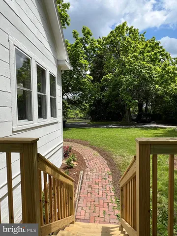 a kitchen with stainless steel appliances granite countertop a sink a stove and a wooden floor