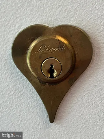 an empty room with wooden floor a kitchen view and windows