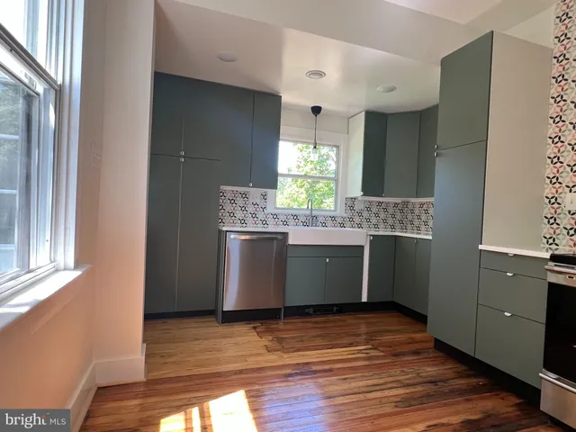 a view of a hallway with wooden floor and windows