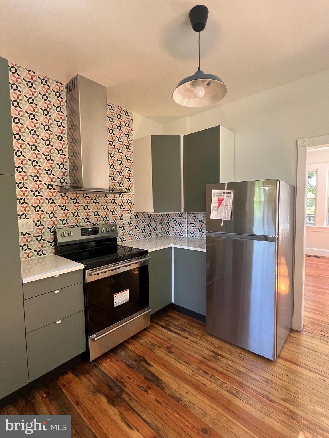 7308 Highbridge Road Bowie, MD 20720 - Photo 28 of 70 a kitchen with stainless steel appliances granite countertop a sink a stove and a wooden floor