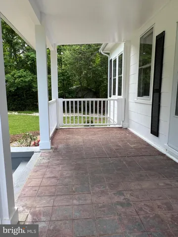 a view of a porch with chairs and backyard of the house