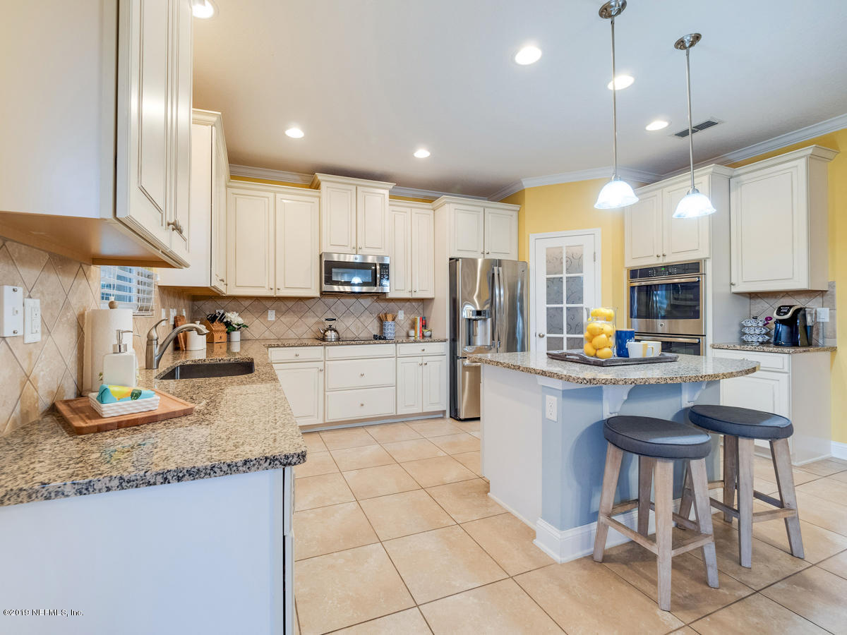 702 Irish Rose Road St. Augustine, FL 32092 - Photo 17 of 53 a kitchen with stainless steel appliances granite countertop a sink a stove a refrigerator cabinets and chairs