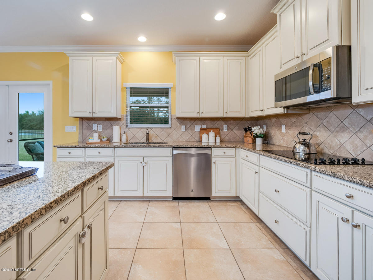 702 Irish Rose Road St. Augustine, FL 32092 - Photo 19 of 53 a kitchen with cabinets appliances a sink and a counter top space