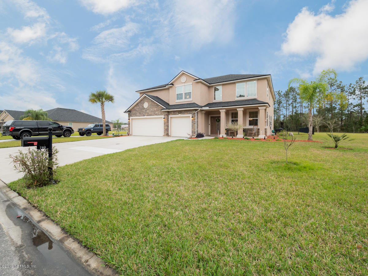 702 Irish Rose Road St. Augustine, FL 32092 - Photo 3 of 53 a view of a house with a big yard and large trees