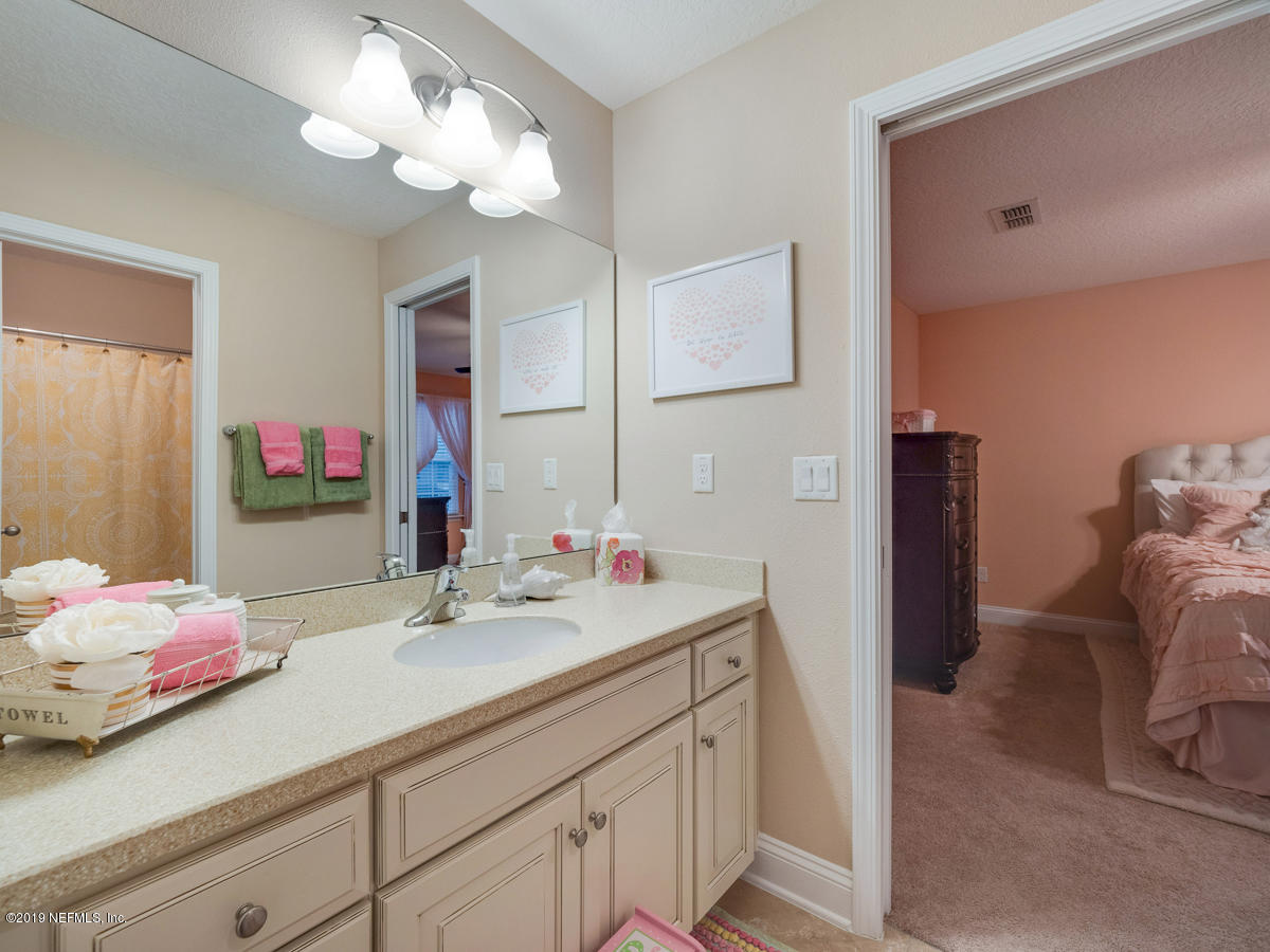 702 Irish Rose Road St. Augustine, FL 32092 - Photo 45 of 53 a en suite bathroom with a double vanity sink and a mirror
