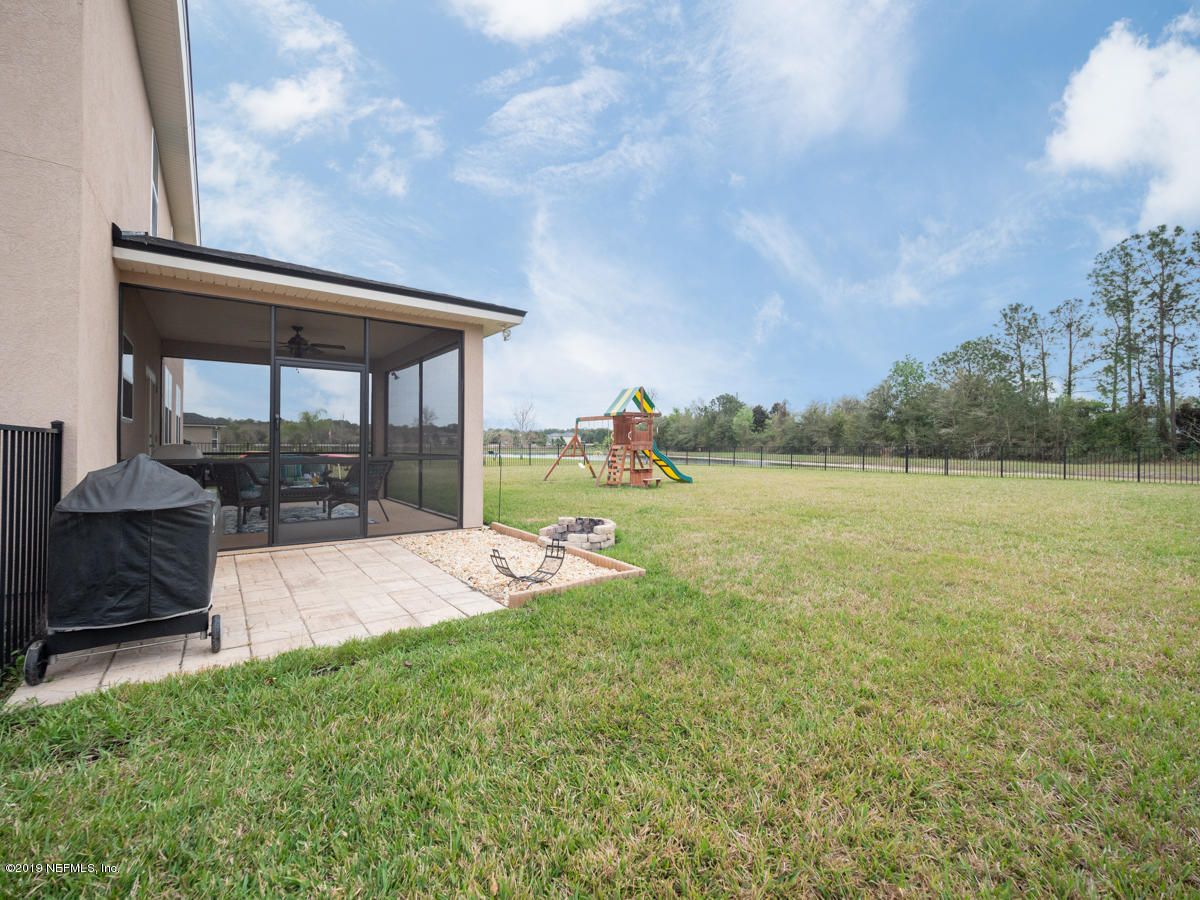 702 Irish Rose Road St. Augustine, FL 32092 - Photo 50 of 53 a view of a backyard with table and chairs under an umbrella