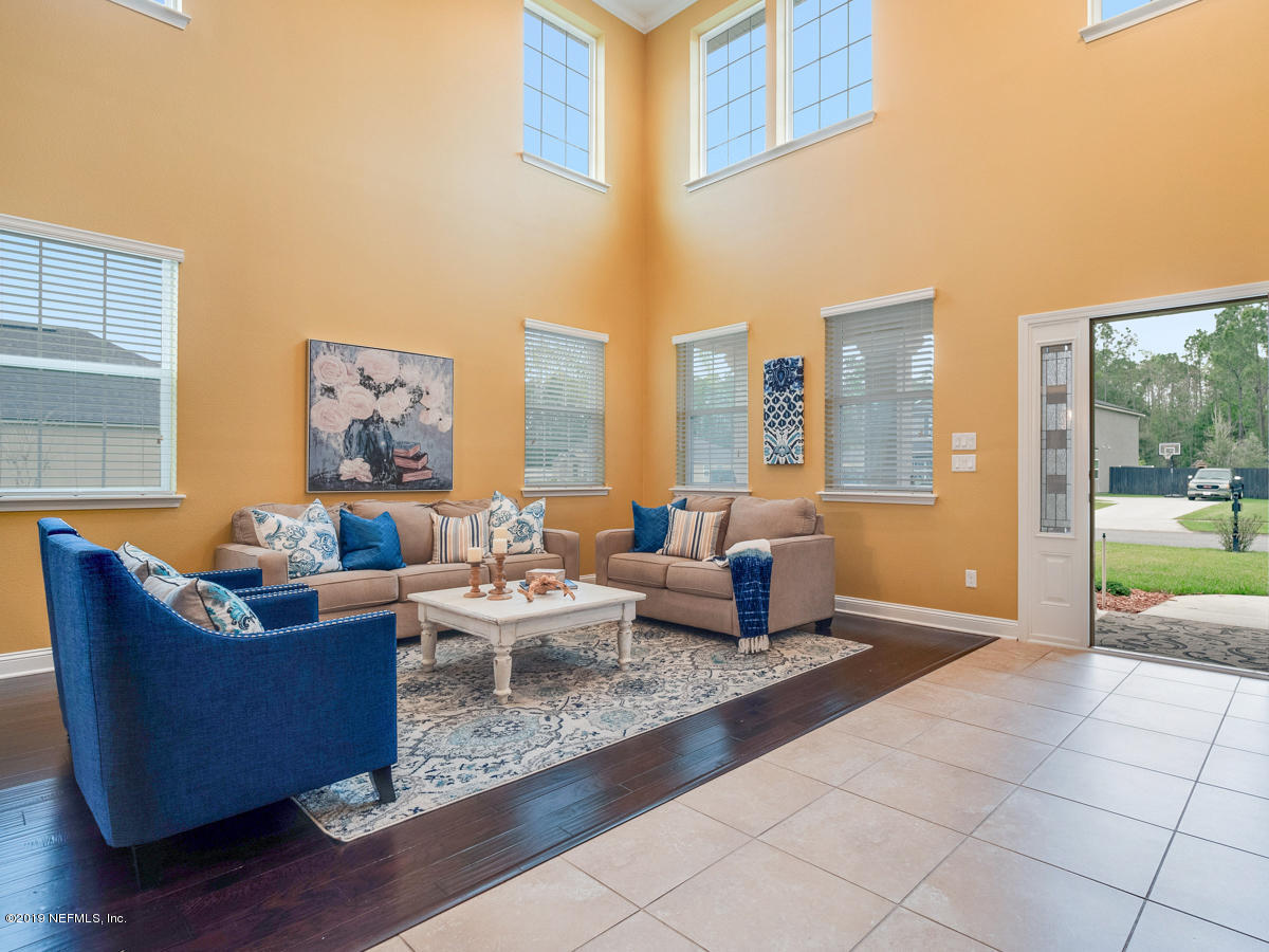 702 Irish Rose Road St. Augustine, FL 32092 - Photo 8 of 53 a living room with fireplace furniture and a floor to ceiling window