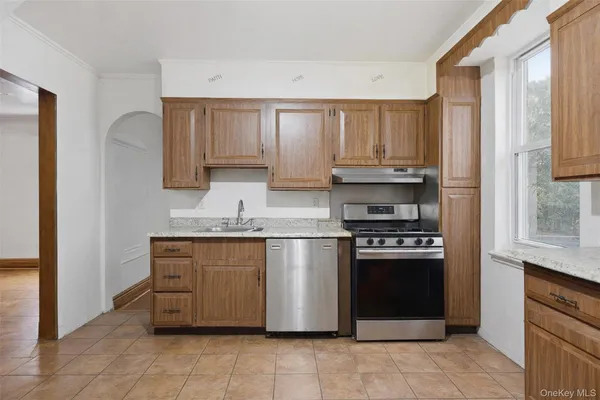 a kitchen with stainless steel appliances granite countertop a stove a sink and a refrigerator