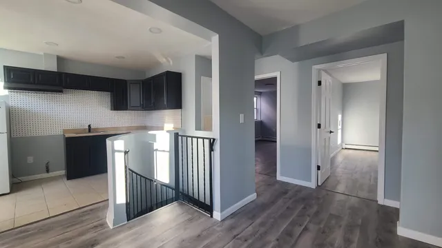 a view of a hallway with wooden floor and cabinets