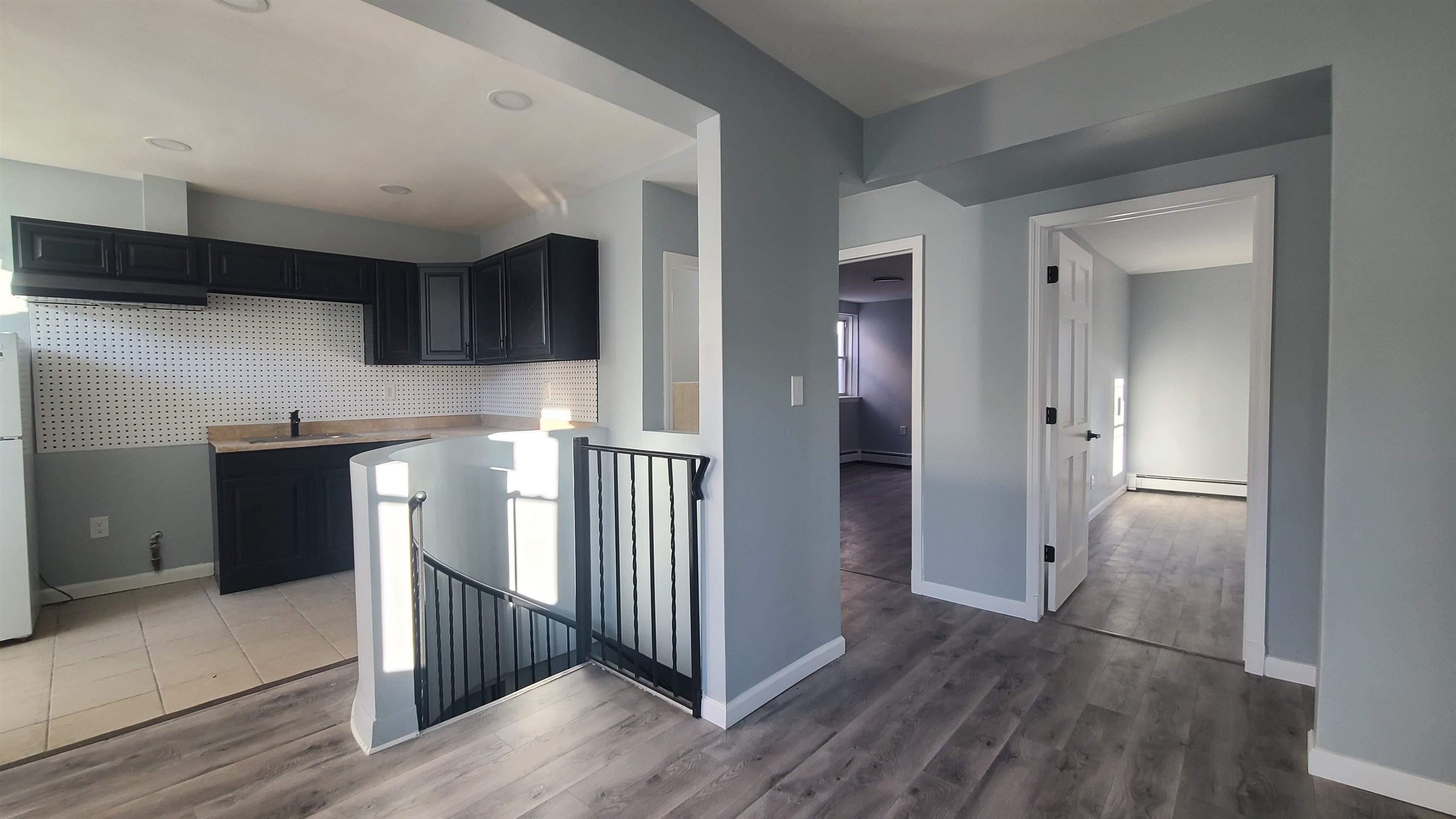 a view of a hallway with wooden floor and cabinets