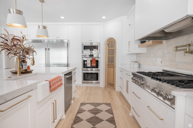 1276 West Fallow Way, Unit 76 Ogden, UT 84414 - Photo 4 of 22 Kitchen with white cabinetry, built in appliances, light wood-style floors, and decorative light fixtures