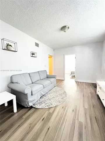 a living room with furniture and a wooden floor