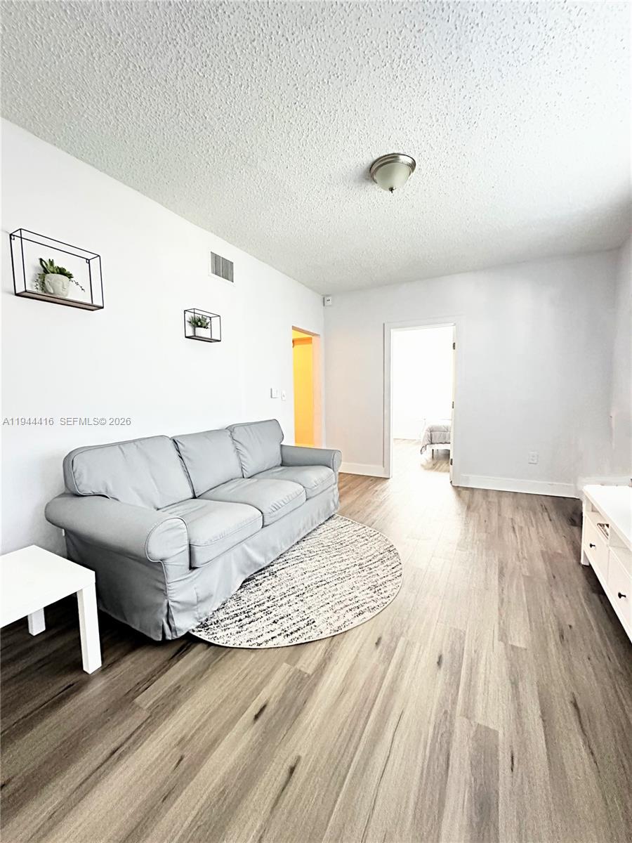 1821 Northwest 33rd Street Miami, FL 33142 - Photo 2 of 18 a living room with furniture and a wooden floor