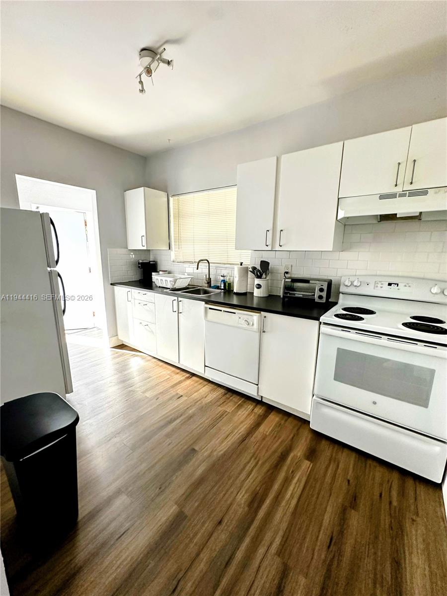 1821 Northwest 33rd Street Miami, FL 33142 - Photo 5 of 18 a kitchen with stainless steel appliances a stove a sink and white cabinets