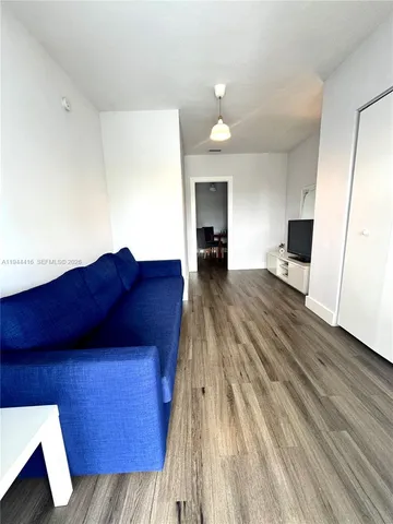 a view of a living room with furniture and wooden floor