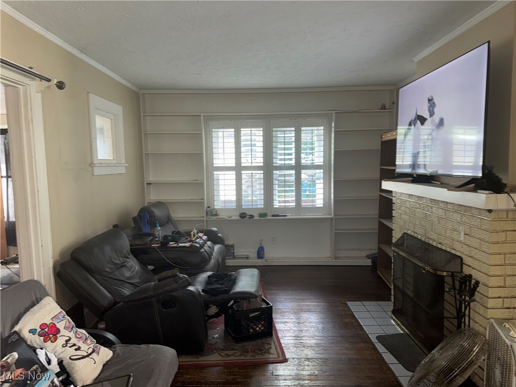 4406 Bayard Road Cleveland, OH 44121 - Photo 2 of 10 Living area with wood-type flooring, ornamental molding, and a brick fireplace