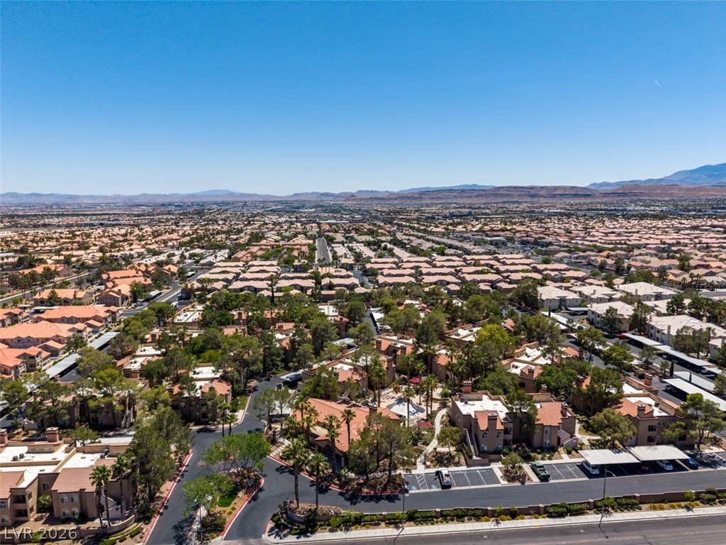 9325 West Desert Inn Road, Unit 244 Las Vegas, NV 89117 - Photo 49 of 55 An aerial panorama reveals a sprawling community amidst a vast landscape, nestled below distant mountain ranges.