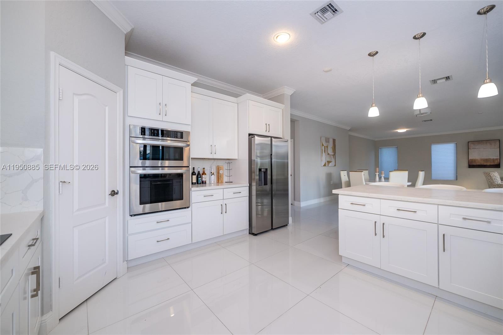 18540 Southwest 43rd Street Miramar, FL 33029 - Photo 13 of 56 a kitchen with stainless steel appliances a refrigerator sink and cabinets