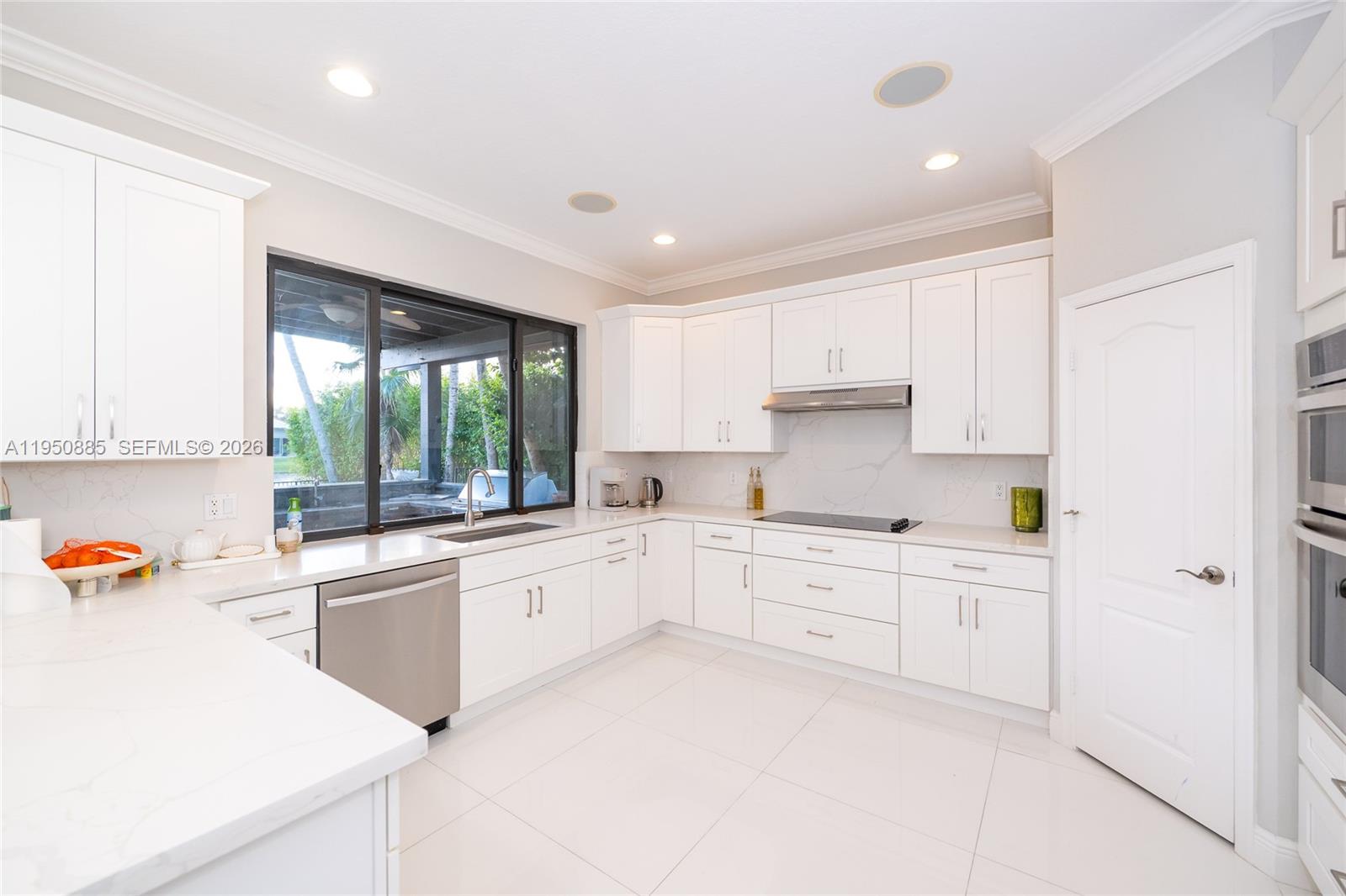 18540 Southwest 43rd Street Miramar, FL 33029 - Photo 14 of 56 a kitchen with white cabinets and white appliances