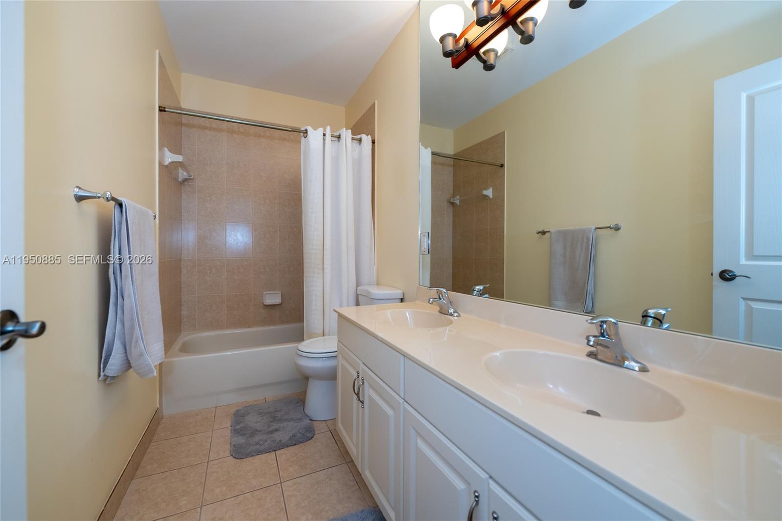 18540 Southwest 43rd Street Miramar, FL 33029 - Photo 34 of 56 a bathroom with a double vanity sink toilet mirror and bathtub