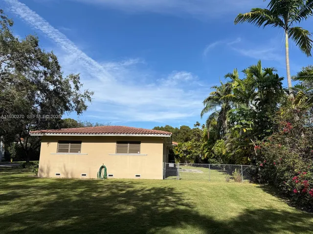 a view of a white house with a big yard