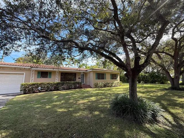 a backyard of a house with garden and outdoor seating