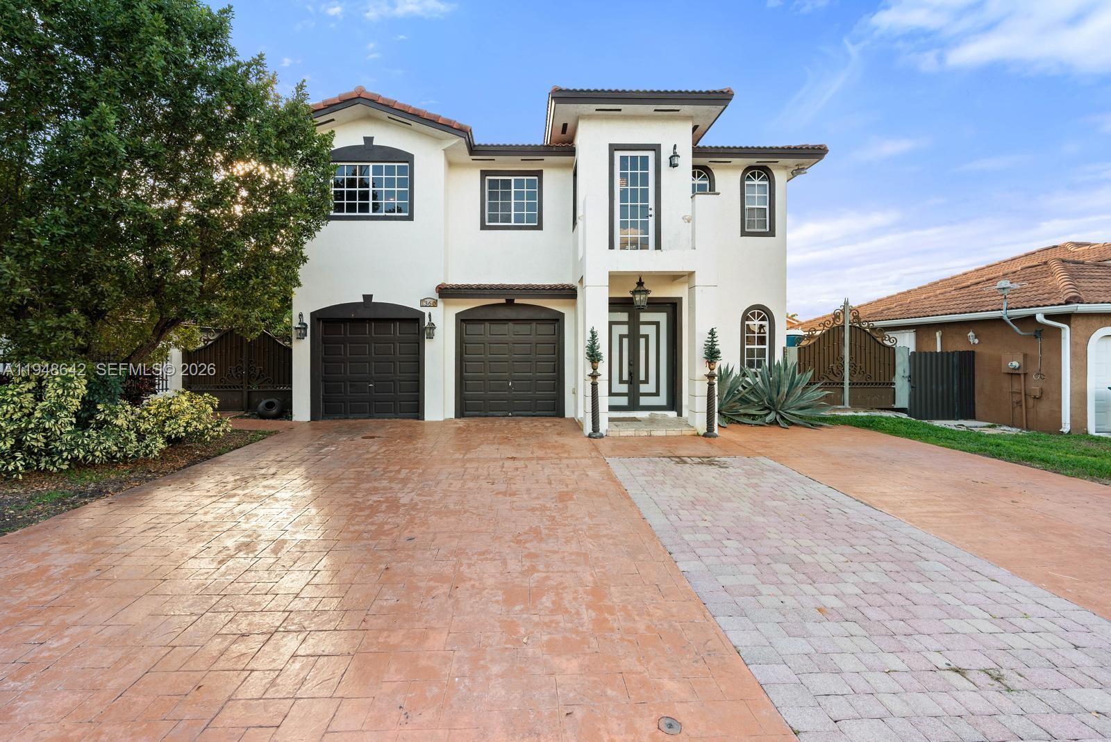 1360 Southwest 142nd Avenue Miami, FL 33184 - Photo 2 of 54 a front view of a house with a yard and garage