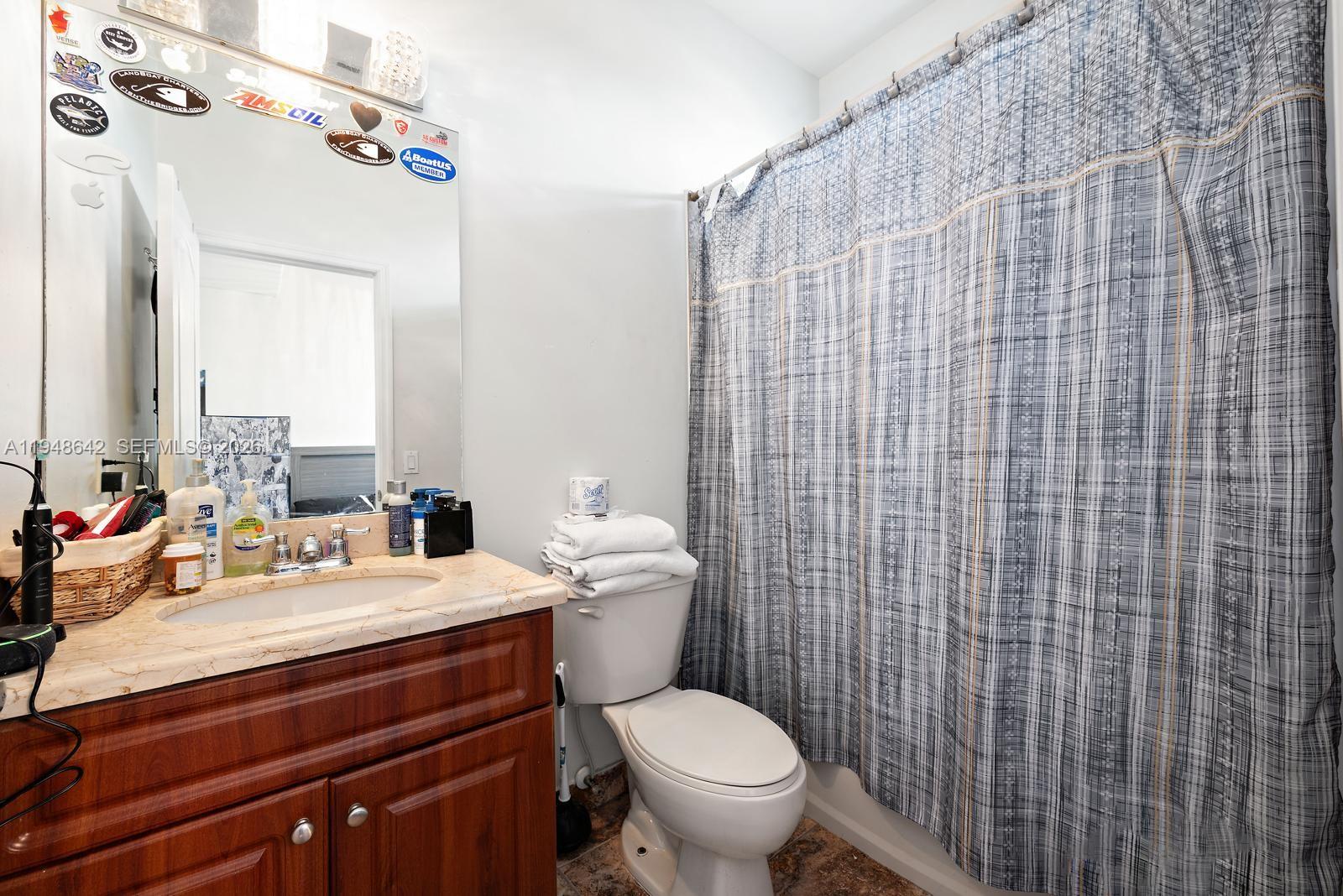 1360 Southwest 142nd Avenue Miami, FL 33184 - Photo 24 of 54 a bathroom with a sink a toilet and shower curtain