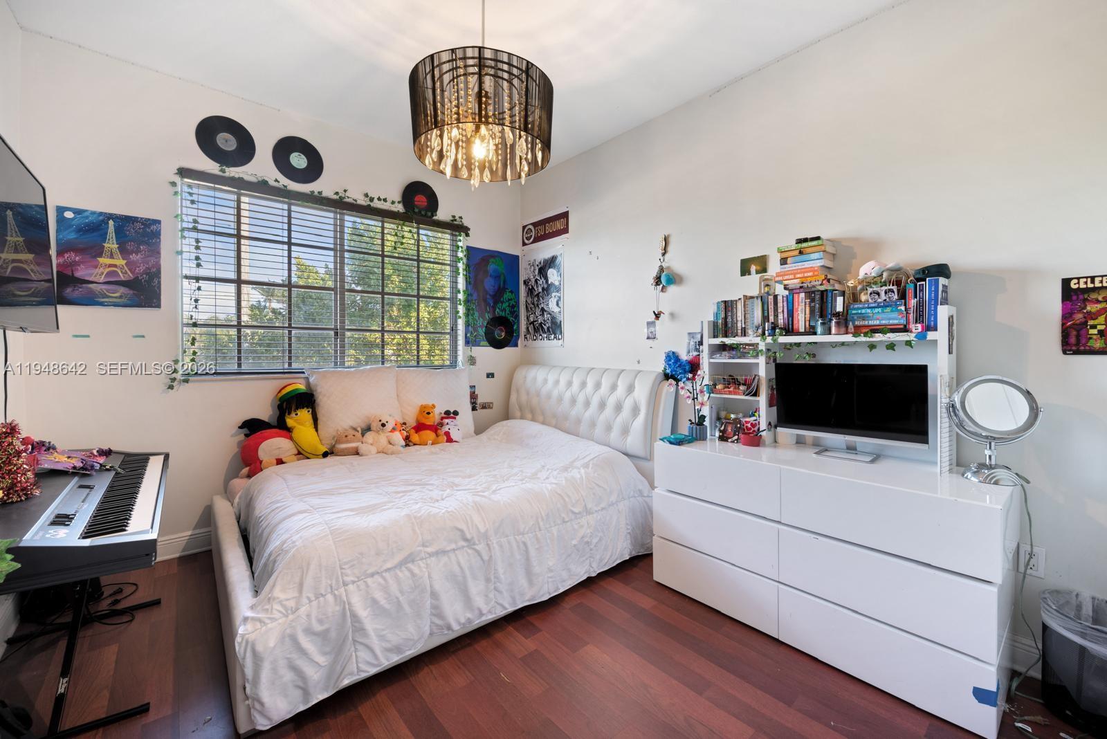 1360 Southwest 142nd Avenue Miami, FL 33184 - Photo 32 of 54 a bedroom with a bed and a chandelier