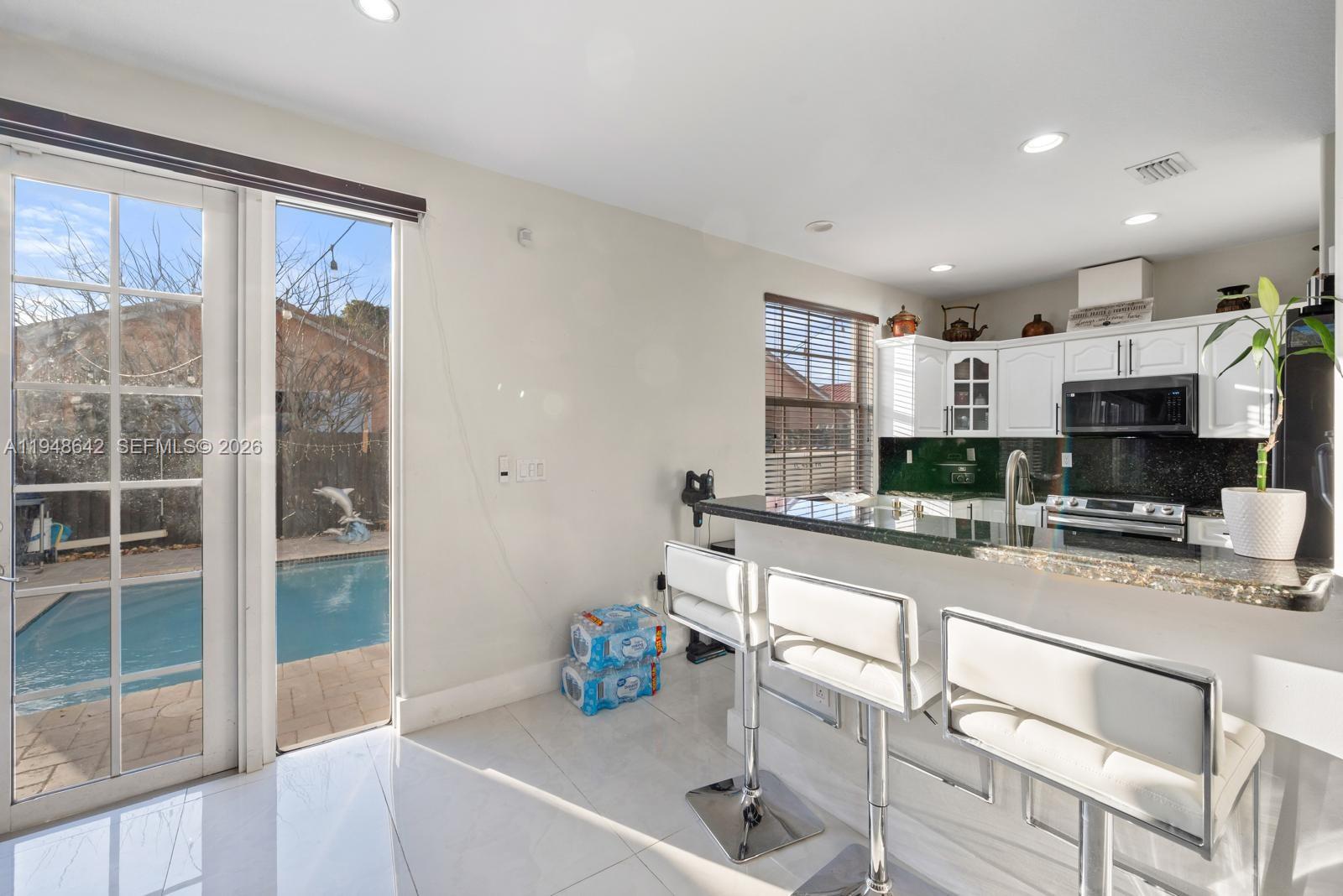 1360 Southwest 142nd Avenue Miami, FL 33184 - Photo 9 of 54 a kitchen with stainless steel appliances granite countertop a sink and cabinets