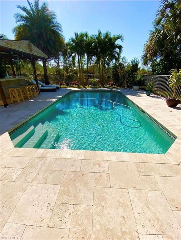 3402 Tigris Lane Naples, FL 34119 - Photo 20 of 50 a view of swimming pool with outdoor seating and plants
