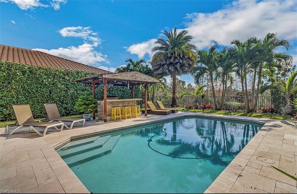3402 Tigris Lane Naples, FL 34119 - Photo 21 of 50 a view of a swimming pool with a patio