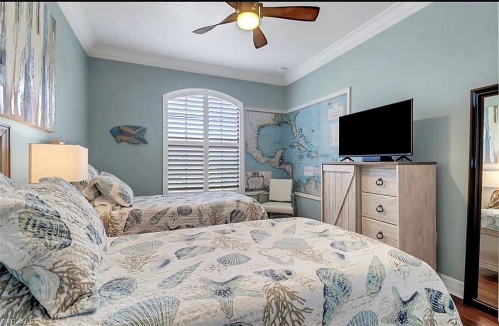 3402 Tigris Lane Naples, FL 34119 - Photo 33 of 50 a bedroom with a large bed and a flat tv screen on dresser