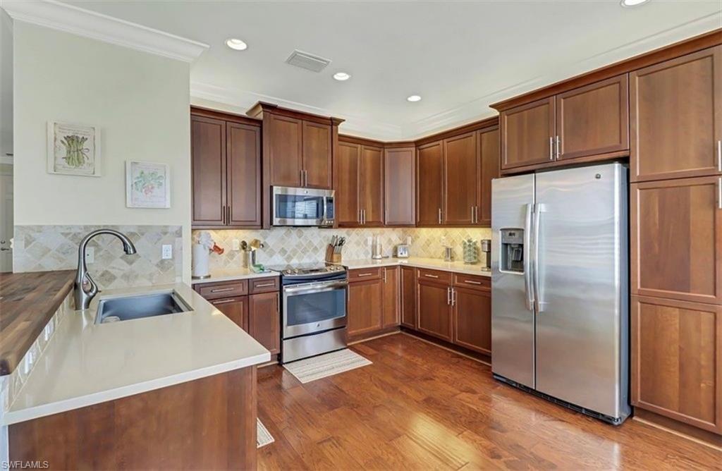 3402 Tigris Lane Naples, FL 34119 - Photo 10 of 50 a kitchen with granite countertop a refrigerator stove top oven and sink