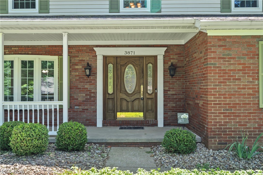 3871 Greentree Road Stow, OH 44224 - Photo 40 of 50 Brick exterior with a prominent wood-finish entry door featuring decorative glass inserts