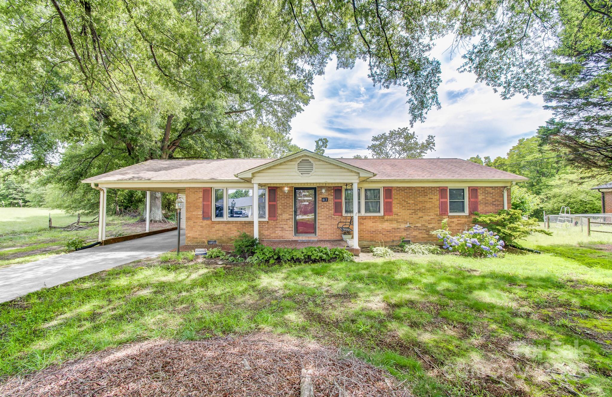 a front view of a house with yard and green space