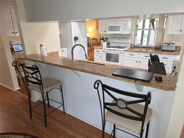 a kitchen with a table chairs stove and cabinets