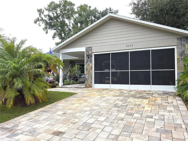 a view of a house with a yard and potted plants