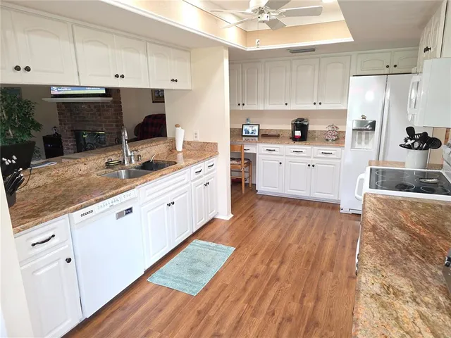 a kitchen with a sink a refrigerator and white cabinets