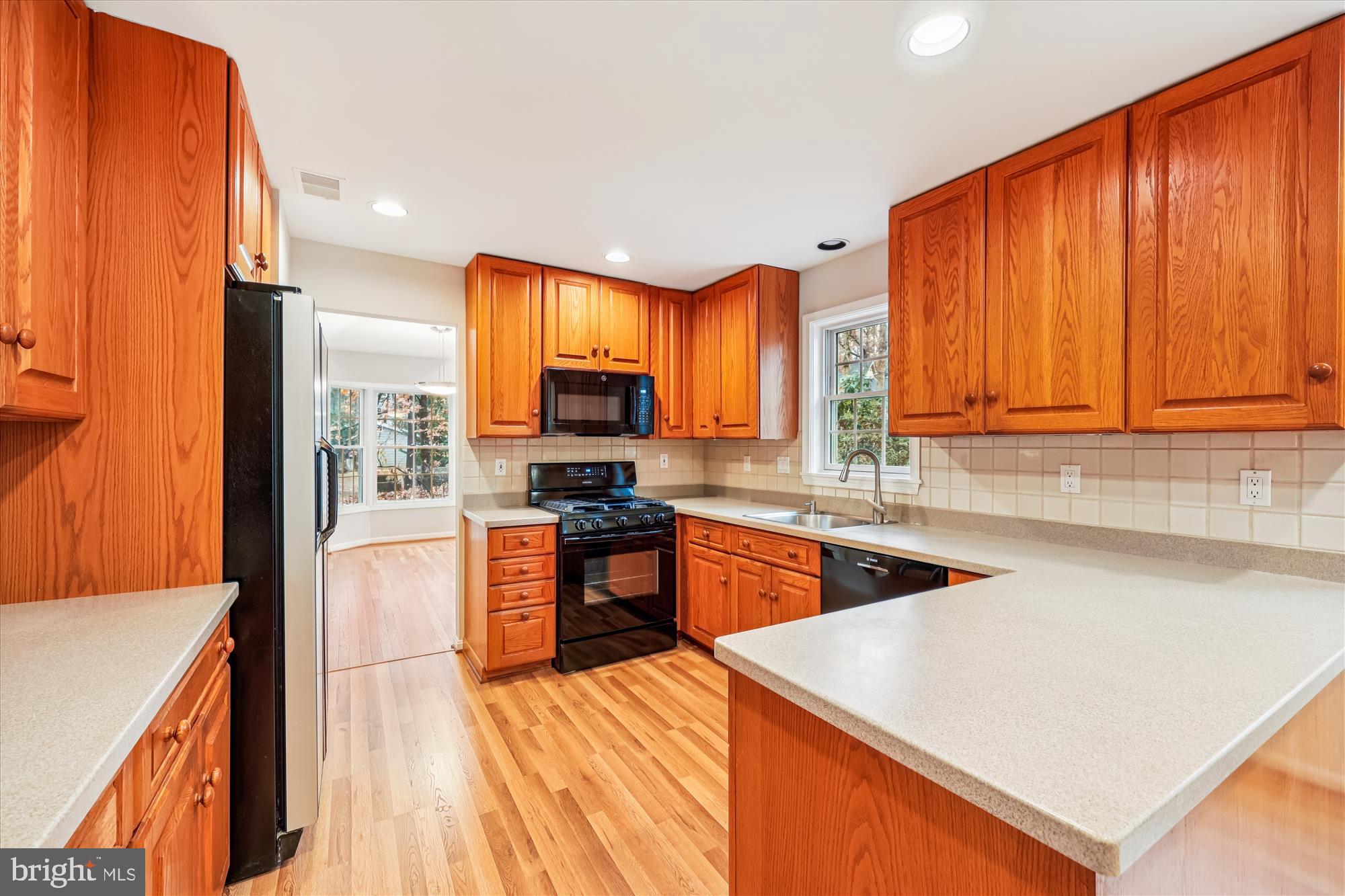 8212 Killean Way Potomac, MD 20854 - Photo 11 of 51 a kitchen with stainless steel appliances granite countertop a stove a sink dishwasher and a microwave with wooden floor